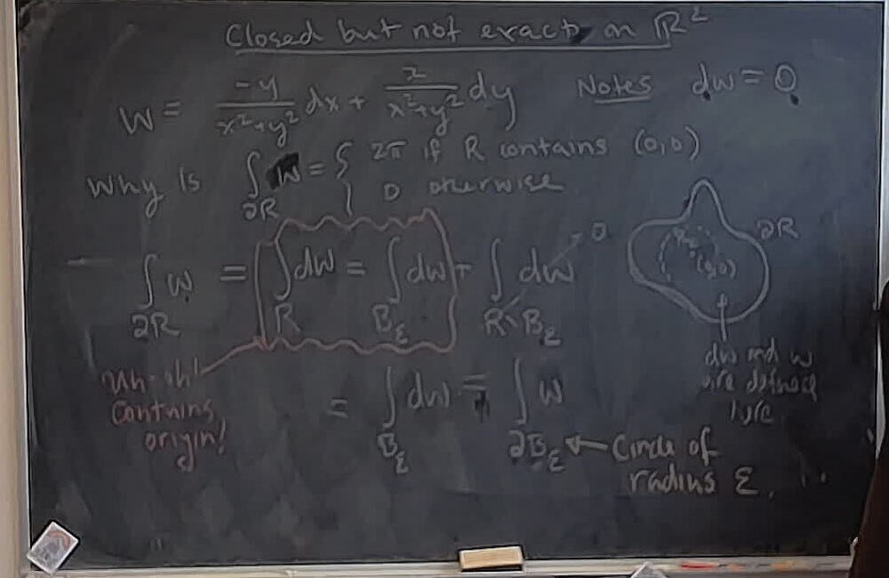 Closed but not exact form on the plane without the origin. A photo of a whiteboard titled: Closed but not exact form on the plane without the origin.